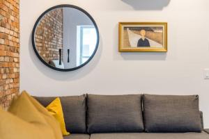 ケベック・シティーにあるINITIAL - SUITE LEMIEUX - PARKING - Centre-Ville de Québecのソファの横に掛け鏡