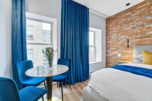 ケベック・シティーにあるINITIAL - SUITE LEMIEUX - PARKING - Centre-Ville de Québecのベッドルーム1室(ベッド1台、テーブル、青い椅子付)