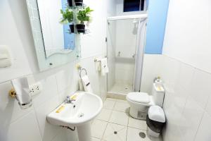 a white bathroom with a sink and a toilet at Hotel Boulevard in Puerto Maldonado