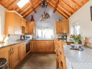 a kitchen with wooden cabinets and a counter top at Stable Cottage in Stoupe Brow