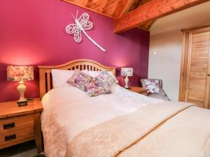 a bedroom with a bed with a butterfly on the wall at Stable Cottage in Stoupe Brow