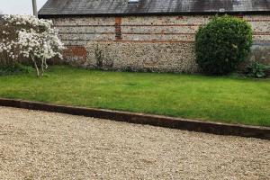 una casa de ladrillo con un patio con césped verde en Renovated cosy cottage within Cranborne Chase, en Handley