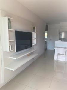 Uma TV ou centro de entretenimento em Golden Lake Arraial do Cabo Resort
