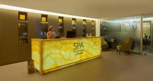 a woman is standing behind a counter in a lobby at InterContinental Cascais-Estoril by IHG in Estoril +37 photos