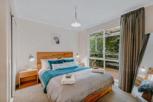 a bedroom with a large bed and a window at Steep Creek Retreat in Belgrave