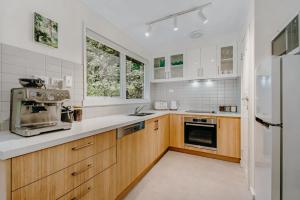 a kitchen with white appliances and wooden cabinets at Steep Creek Retreat in Belgrave