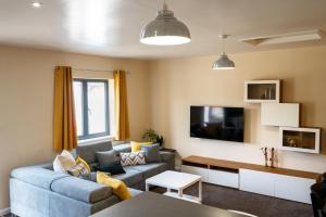 a living room with a couch and a tv at LITTLE HOUSE - Perfect for exploring The Broads in Acle