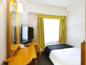 Habitación de hotel con cama y escritorio con TV. en APA Hotel Chiba Yachiyo Midorigaoka en Yachiyo