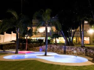 duży basen z palmami przed budynkiem w obiekcie Huge Golf and Spa Mansion 8 min from Puerto Banus w mieście Estepona
