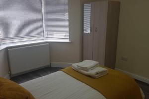 a bedroom with a bed with two towels on it at Homely Experience for Contractors,Grays in Grays Thurrock
