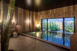 a swimming pool in a room with a large window at Hotel Route-Inn Mihara Ekimae in Mihara