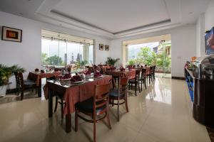a restaurant with wooden tables and chairs and windows at Sapa Mountain Queen House in Sapa