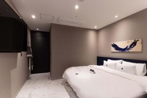 sypialnia z dużym białym łóżkiem w pokoju w obiekcie Zam101 Hotel Gimhae w mieście Gimhae