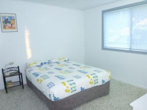 Bett in einem weißen Zimmer mit Fenster in der Unterkunft Koala Lodge Unit 3 in Iluka