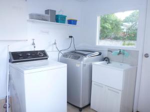 a laundry room with two washer and dryers and a window at Koala Lodge Studio 1 in Iluka
