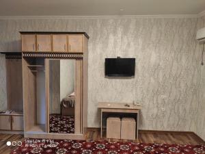 Habitación con espejo y TV en la pared. en MOTEL LION en Urganch