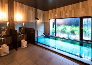 a swimming pool in a room with a large window at HOTEL ROUTE-INN Osaka Takaishi Hagoromo Ekimae in Takaishi