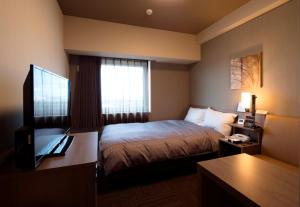 เตียงในห้องที่ HOTEL ROUTE-INN Osaka Takaishi Hagoromo Ekimae