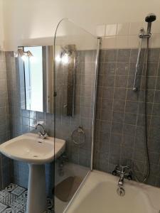La salle de bains est pourvue d'une douche, d'un lavabo et d'une baignoire. dans l'établissement T3 proche de la mer, à Portel-des-Corbières