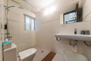 a white bathroom with a sink and a toilet at Mu Lake Villa 慕湖休閒包棟民宿 宜蘭縣民宿2085號 in Dongshan