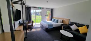 ロトルアにあるHideaway of Rotoruaのベッドとソファ付きのホテルルーム
