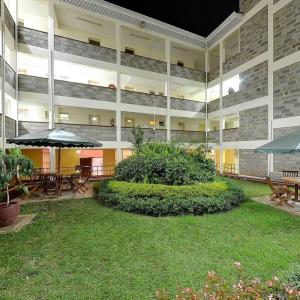 un patio con mesas y sombrillas en un edificio en Adventist LMS Guest House & Conference Centre, en Nairobi