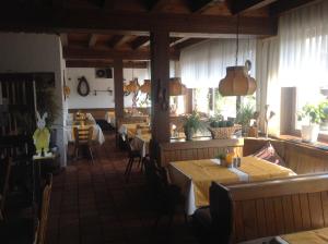 ein Restaurant mit Tischen und Stühlen in einem Zimmer in der Unterkunft Landgasthof zum Wiesengrund in Hünfeld
