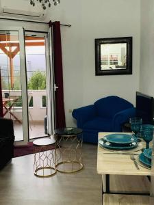 sala de estar con sofá azul y mesa en Almira sea view Appartment en Istron