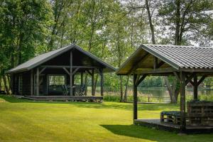 a gazebo with a bench in a park at VieniKrante in Utena
