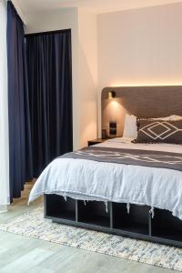 a bedroom with a large bed with blue curtains at Scape Living at Aurora in Melbourne