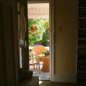 una puerta abierta a un patio con mesa y silla en Australis Guest House en Ottawa