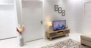 a living room with a television and a vase of flowers at مساكن الدار 2 in Abha