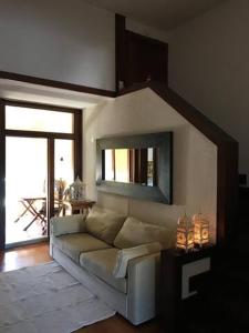 ein Wohnzimmer mit einem Sofa und einem Spiegel in der Unterkunft T1 Troia Resort - Praia Mar in Comporta