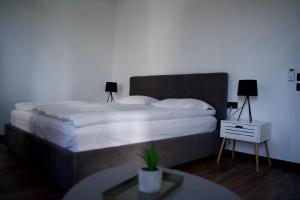 a bedroom with a large bed with white sheets and a table at Style Hotel in Ungheni