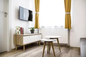 a living room with a table and a tv on a wall at Gliwice on a budget 90m from the main square in Gliwice
