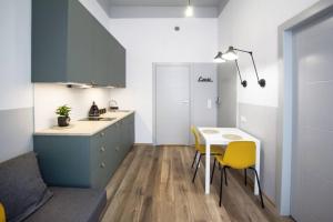 a kitchen with a table and yellow chairs at Gliwice on a budget 90m from the main square in Gliwice