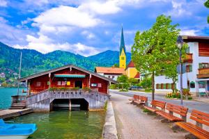 a bridge over a body of water with a church at Haus Kaiser in Rottach-Egern