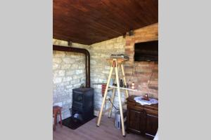 a room with a wood stove and a ladder at Guest House Kostadinovi in Bŭlgarevo