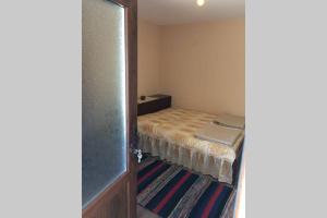 a small bedroom with a bed and a television at Guest House Kostadinovi in Bŭlgarevo