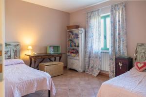 アトリにあるCasale Vittoriaのベッドルーム1室(ベッド2台、テーブル、窓付)