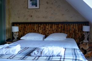 a bedroom with a bed with white sheets and pillows at Auberge du Manet in Montigny-le-Bretonneux