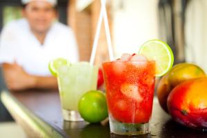 Dos cócteles sentados en una mesa con fruta. en Pousada Afrika, en Búzios