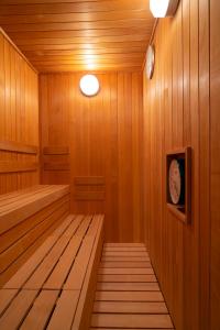 uma sauna com painéis de madeira e um relógio na parede em Torifito Hotel & Pod Kanazawa em Kanazawa