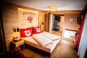 a bedroom with a bed with red pillows at Angerhof Apartment in Fiss +21 photos