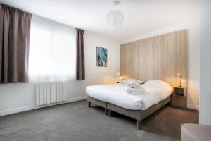 a bedroom with a bed and a large window at Hôtel La Petite Sirène Quiberon in Quiberon