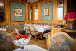 a restaurant with a table and chairs and a dining room at Ferienhotel Angerhof in Fiss