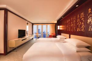 a hotel room with a large bed and a television at Grand Hyatt Shanghai in Shanghai
