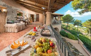 a table with fruits and vegetables on a balcony at Hotel Porto Pirgos in Parghelia