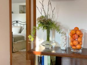 einen Tisch mit einer Vase Orangen auf einem Regal in der Unterkunft Residence e B&B Villamirella in Palinuro