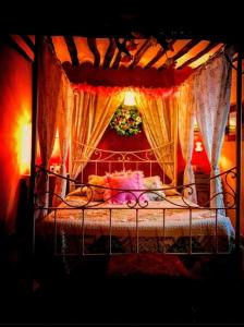 Room in Lodge - Romantic getaway to Cuenca at La Quinta de Malu في Valeria: غرفة نوم بسرير مع ستارة وستائر